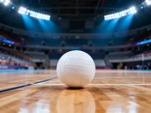 Widok z góry na profesjonalny kort do badmintona z lotką przy siatce. Oświetlona hala sportowa w tle.